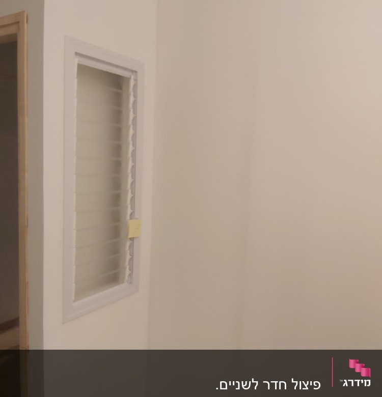 קיר גבס עם חלון קטן ותריסים